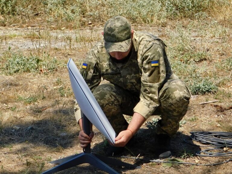 Militar ucrainean instalând un terminal Starlink pe teren, fotografie de arhivă din 2022