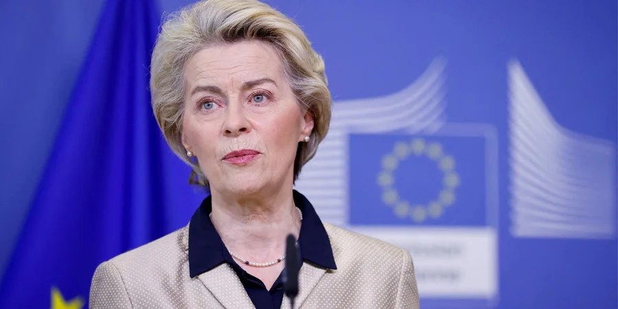 Ursula von der Leyen în fața unui fundal albastru cu emblema Uniunii Europene.