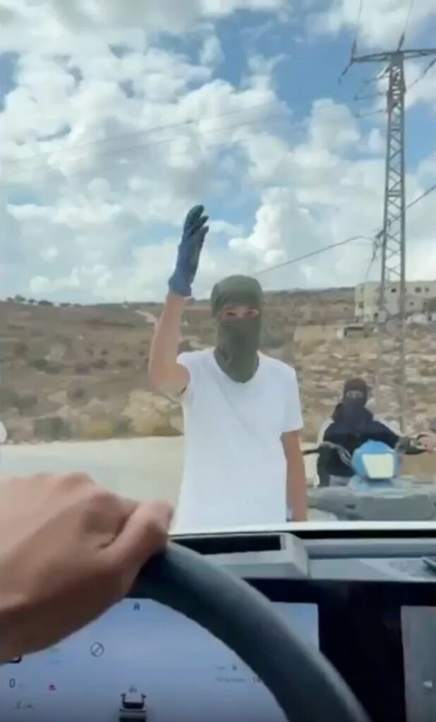 Coloniști mascați în fața unei mașini la Taybeh, într-o captură video din 17 octombrie