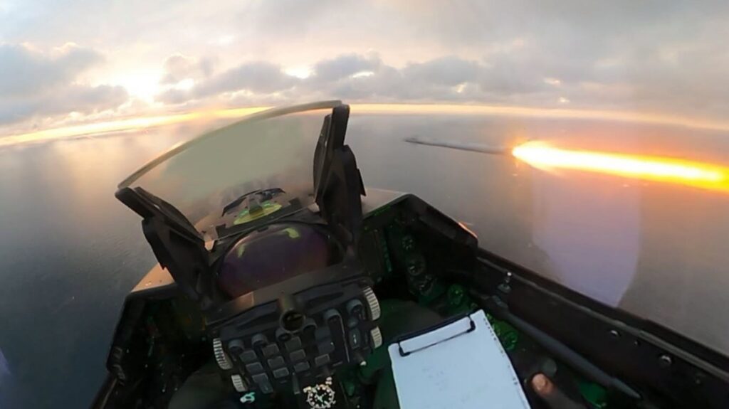 Vedere din cabina unui F-16 deasupra Mării Negre, cu o urmă luminoasă în partea dreaptă a imaginii