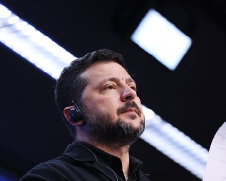 Volodymyr Zelenskyy la un eveniment public, sub luminile unei săli.